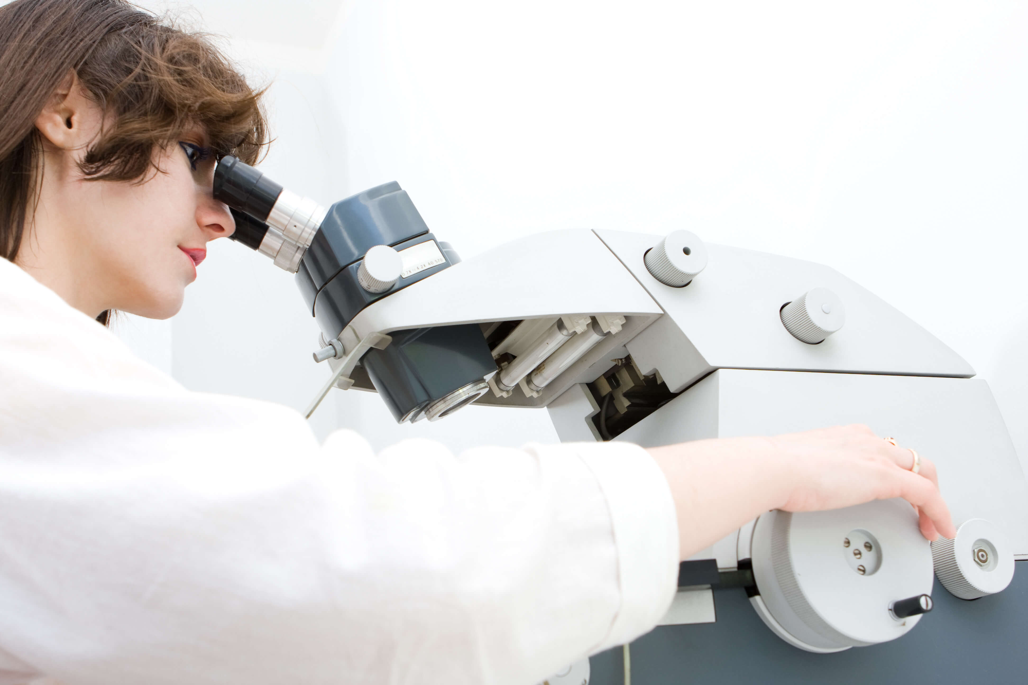 Scientist examining samples under a microscope